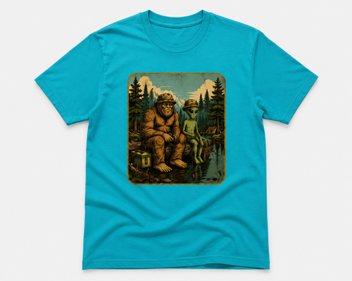 A bright turquoise blue short-sleeve t-shirt with a rectangular vintage-style graphic print on the chest showing a Bigfoot and an alien sitting by a lake in a forest.